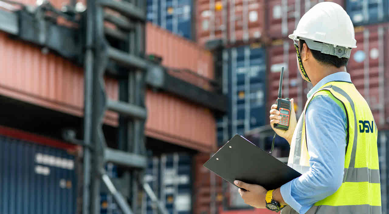 DSV employee in front of cargo containers